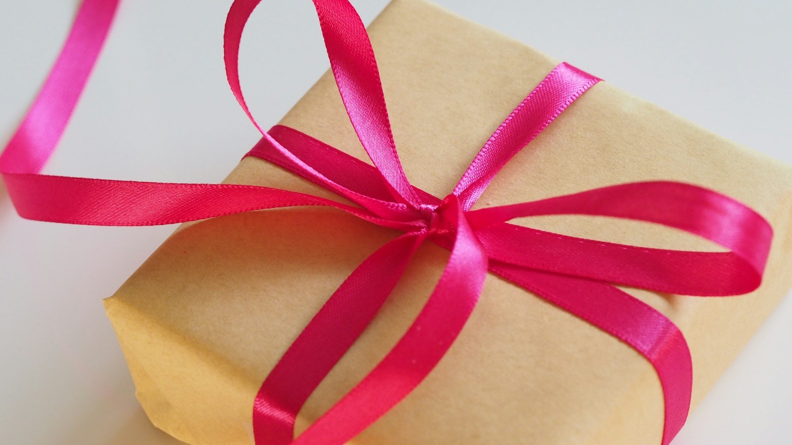 Cadeau verpakt in bruin papier met een roze lint