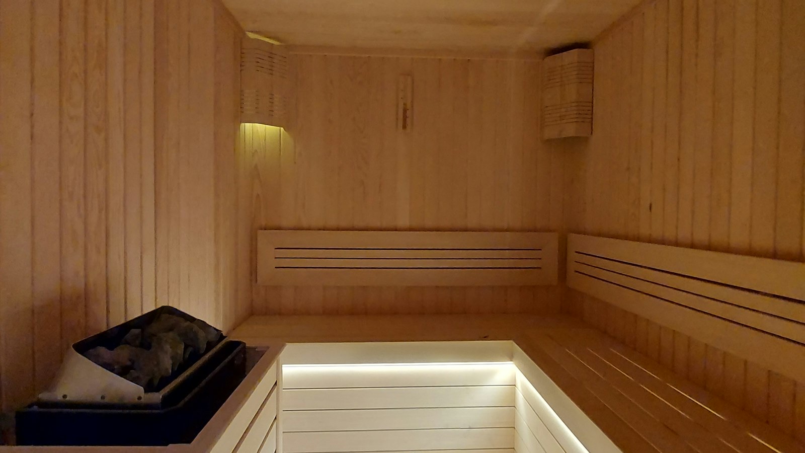 Lege saunaruimte met houten banken en sfeerverlichting
